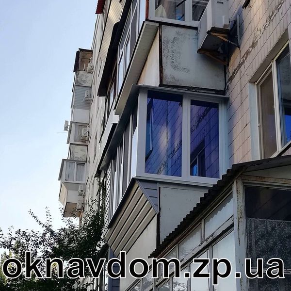 Балкон у 9-поверхівці з розваркою під підвіконня (коротка косинка) в Запоріжжі. У випадку коли перила — це бетонна плита, доцільніше робити розварку коротка косинка — коли зашивається лише частина, де зроблено винос. Обшивка сайдинг. Пластикові вікна на балкон г-подібно, фасадна частина з двома відкриваннями, бічне вікно з відкриванням для миття та обслуговування кондиціонера. Зроблено підлогу, утеплення з внутрішньою обшивкою балкона. Скло рефлекторне блакитного кольору.