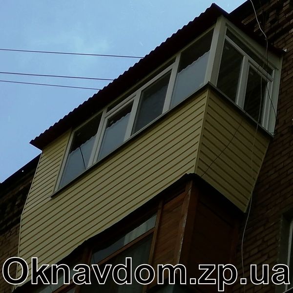 Балкон під ключ у Запоріжжі. Розварка балкона з виносом уперед і вбік, де бічне вікно. Обшивка сайдинг, дах безшумний із керамопласту. Г-подібне скління балкона з профілю Steko