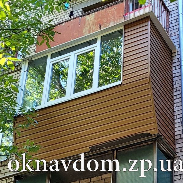 Балкон у цегляній хрущовці, зроблено розварку під підвіконня з новими перилами, обшито сайдингом під золотий дуб, зроблено оцинкований козирок (проклеєний бітумною стрічкою для віброізоляції), г-подібне скління вікна Rehau.